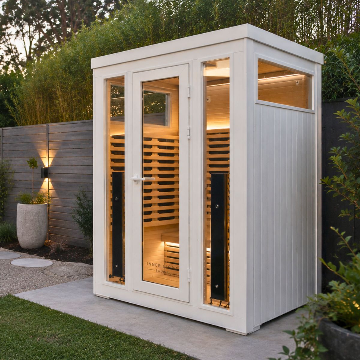 White outdoor infrared sauna in the garden.